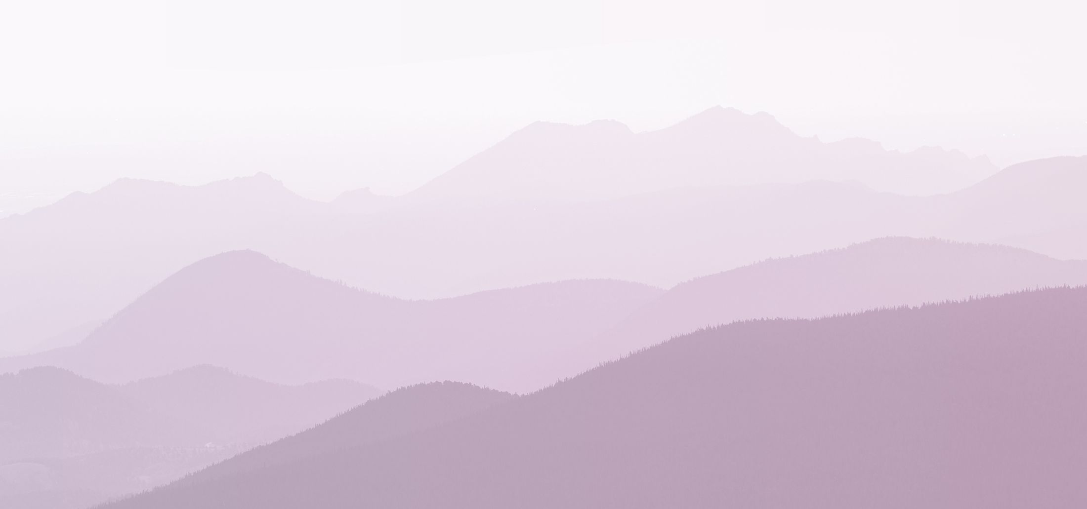 Soft, layered mountains in pastel purple hues.