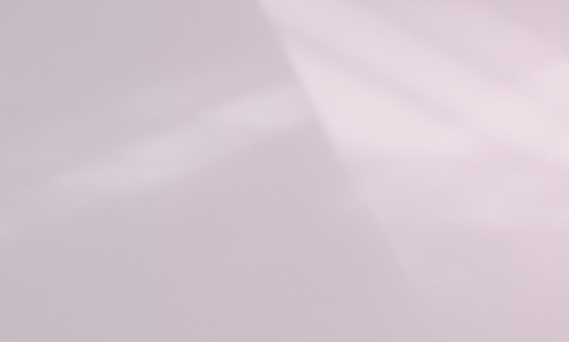 Soft pink abstract background with light reflections.