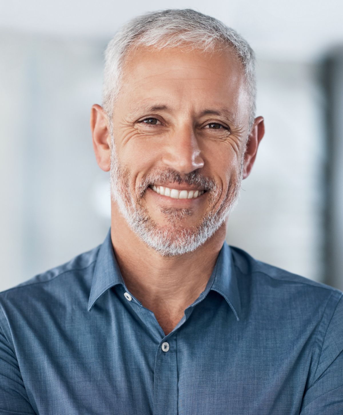 Smiling older man in a blue shirt.