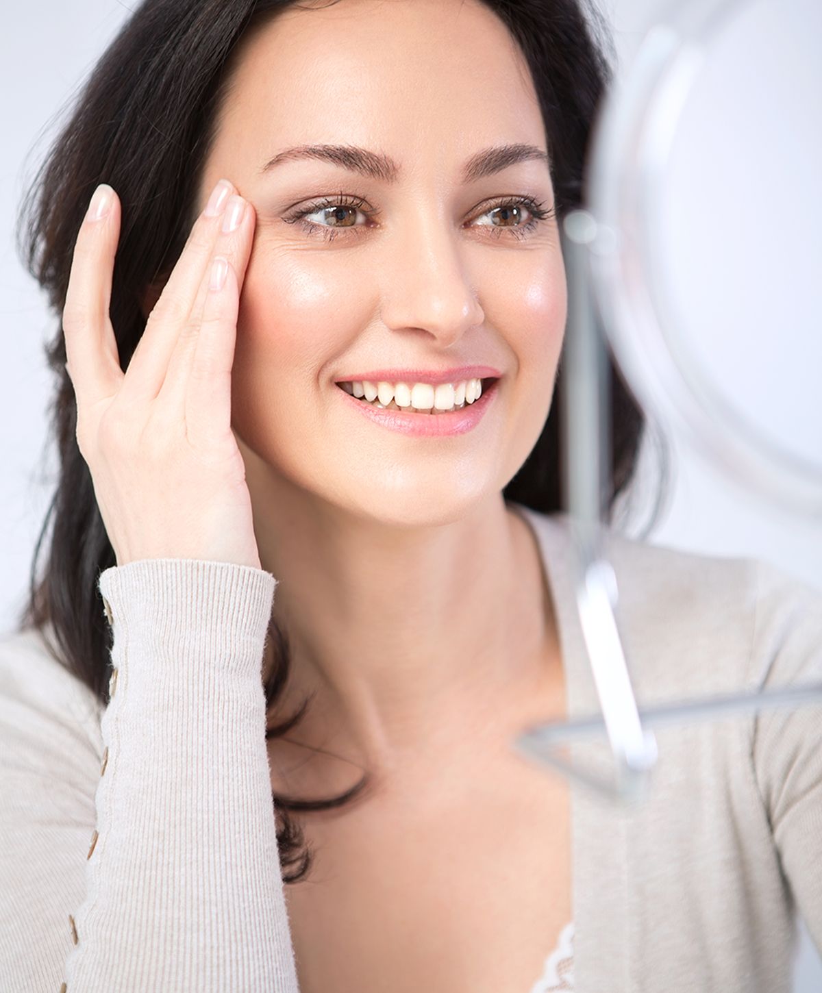Woman smiling while looking in mirror.