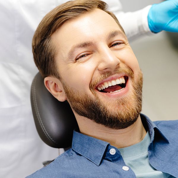 Smiling man in dental chair during appointment.