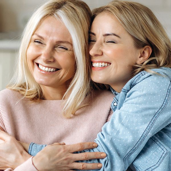 Two women smiling and hugging joyfully