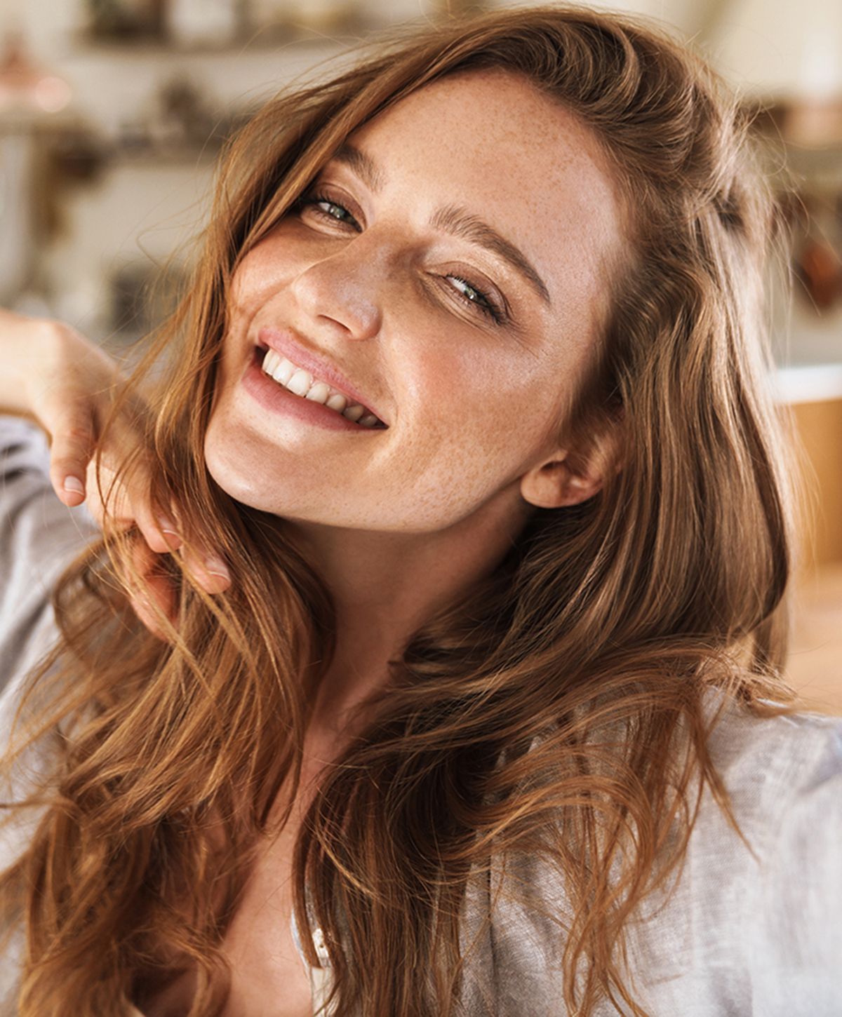 Smiling woman with long, wavy hair.
