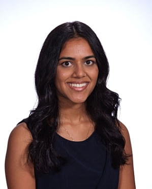 Smiling woman with long black hair in portrait.
