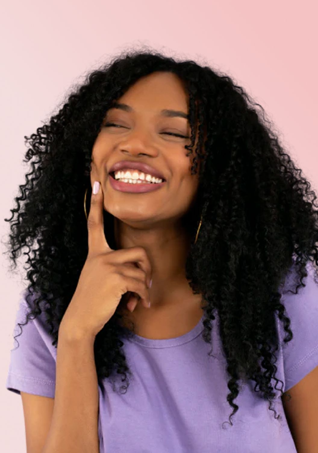 Smiling woman with curly hair contemplating an idea.