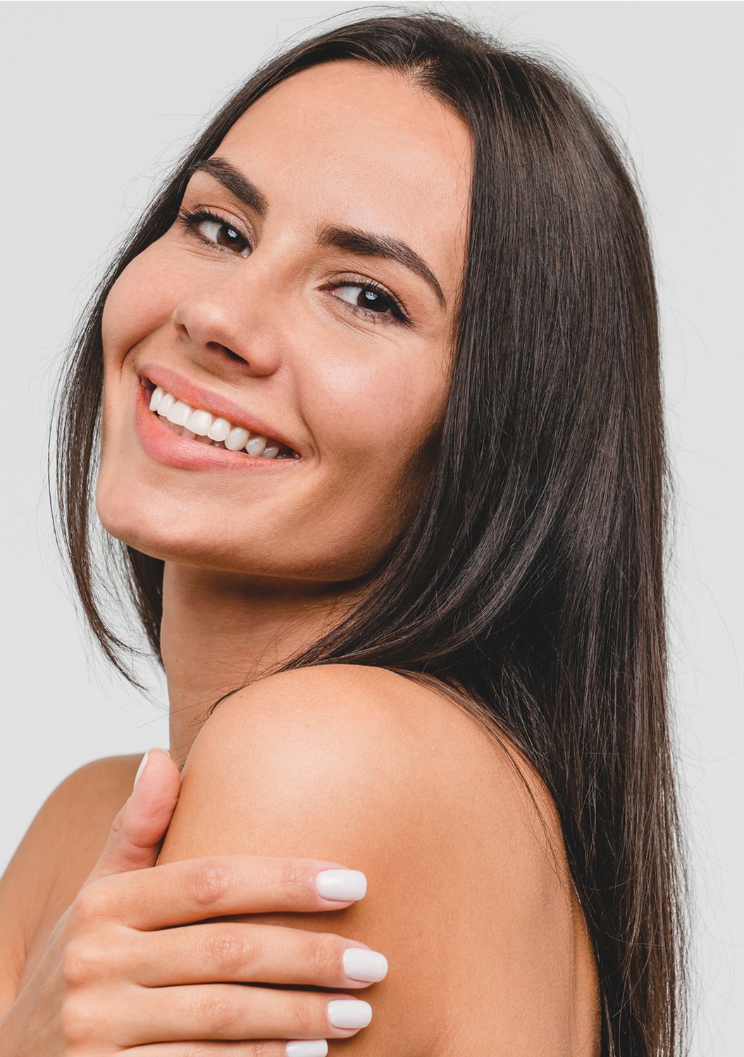 Smiling woman with long hair and bare shoulders.