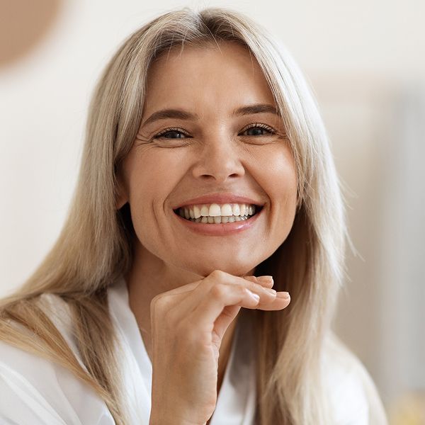 Smiling woman with blonde hair and healthy teeth.