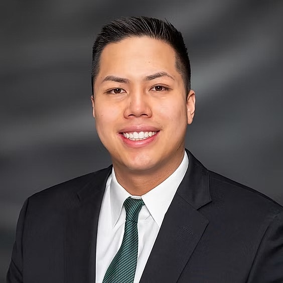 Professional headshot of a smiling man.