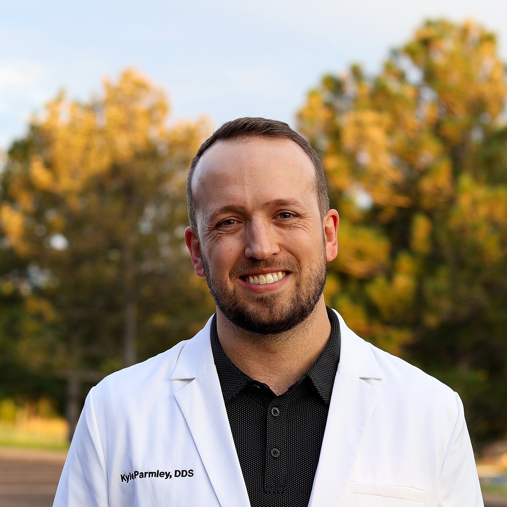 Smiling man in suit against gray background.