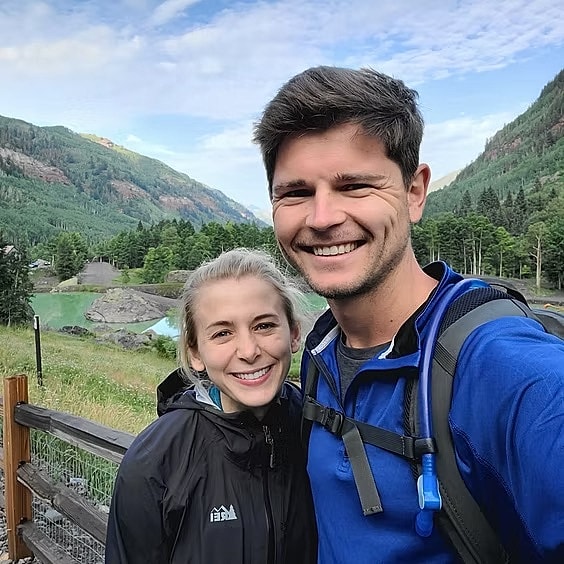 Smiling couple in scenic outdoor setting.