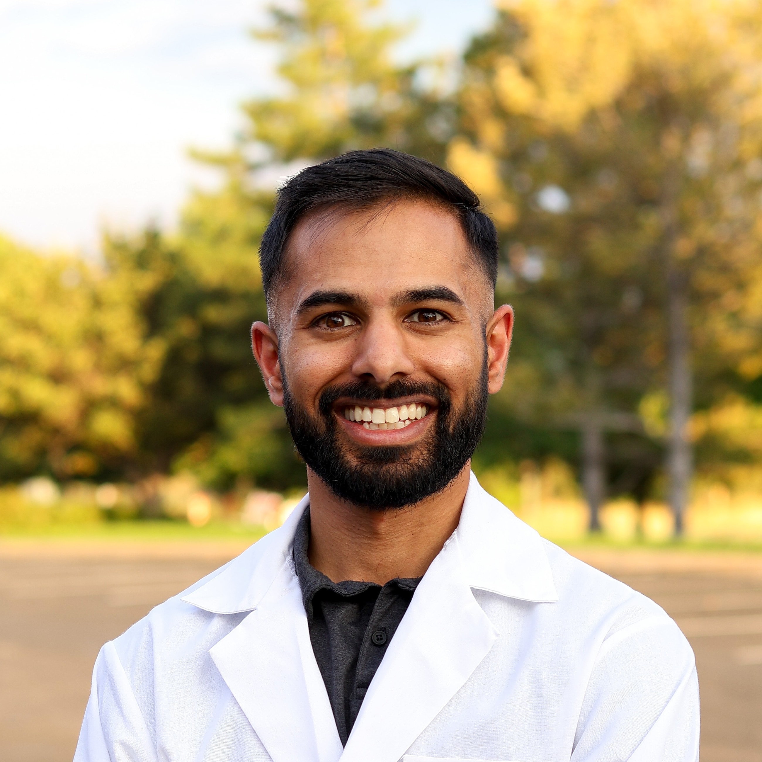 Smiling man in a white shirt and tie.