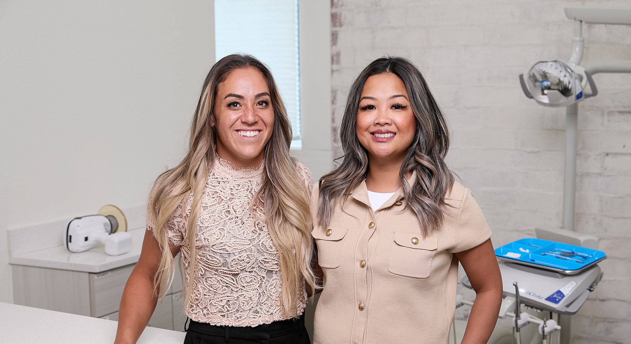 Two women posing in a dental office.