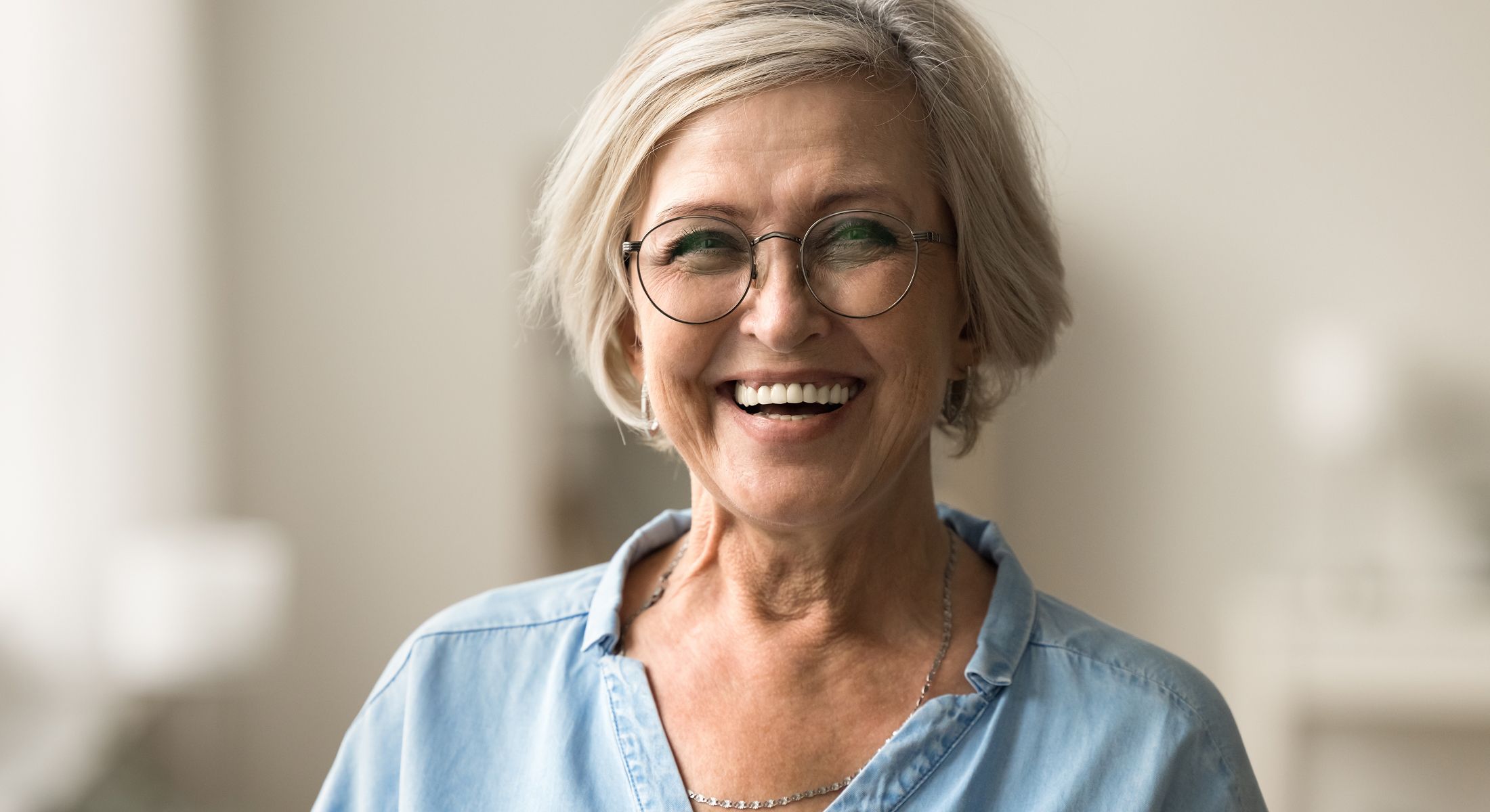 Smiling older woman wearing glasses indoors.