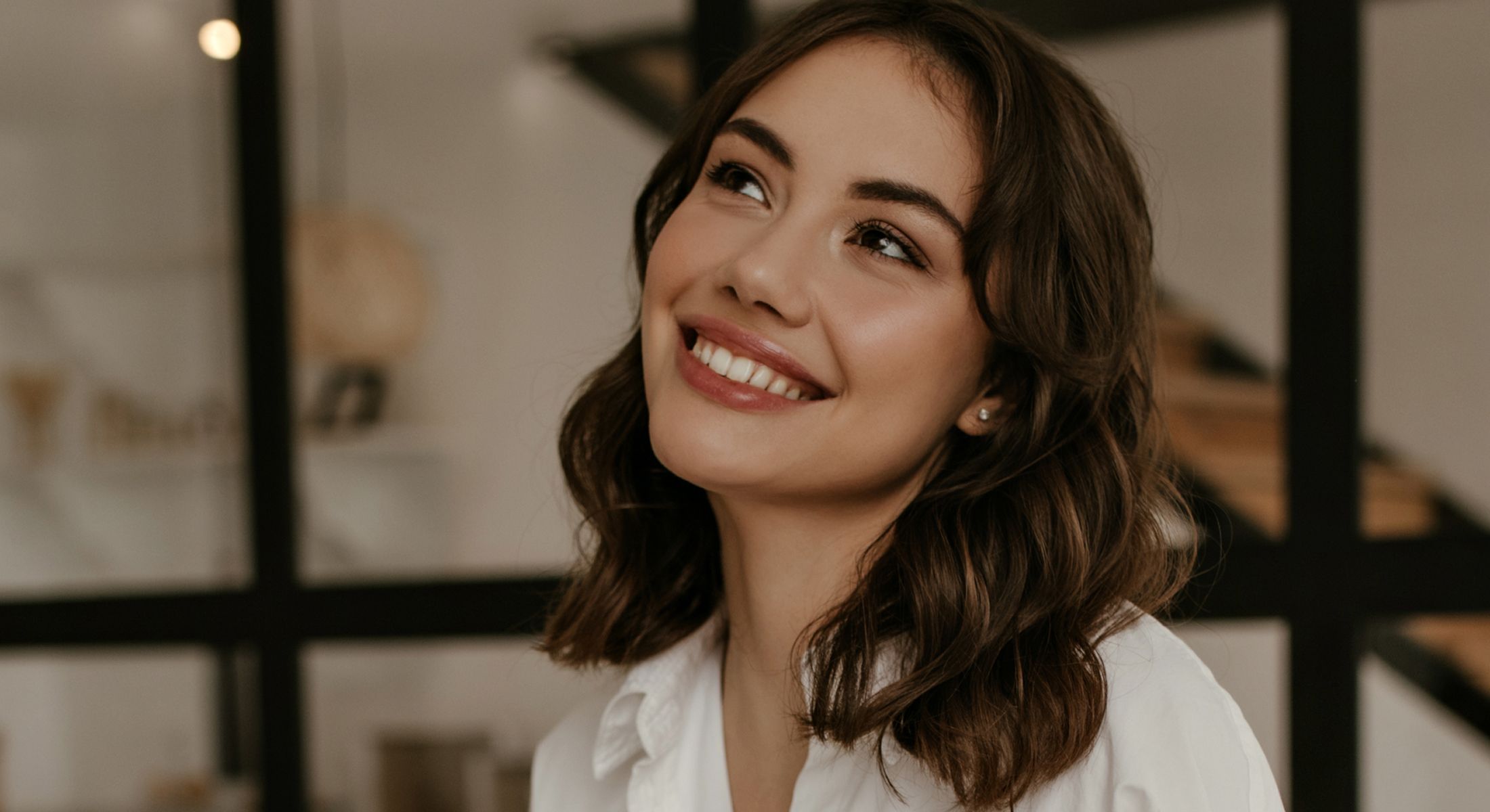 Smiling woman in cozy indoor setting.